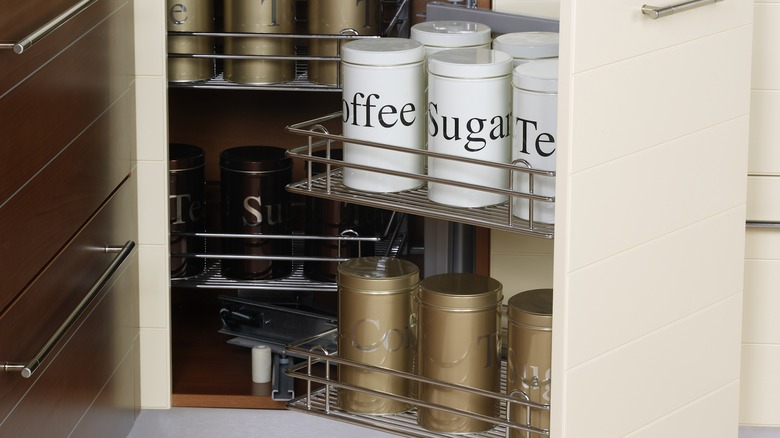 corner kitchen cabinet with pull out storage and items stored in back of cabinet