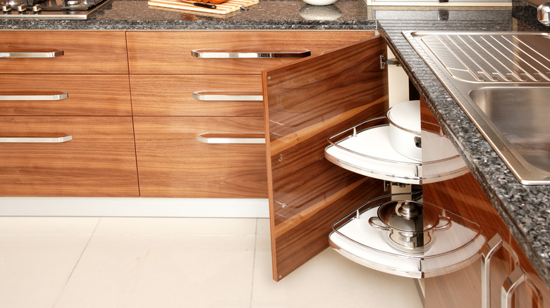 kitchen corner cabinet with large pans in front