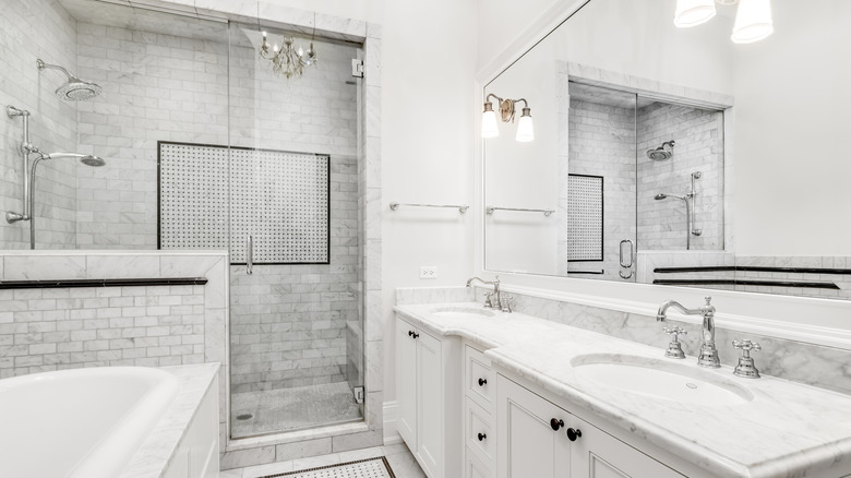 All white bathroom with double vanity and lots of lighting