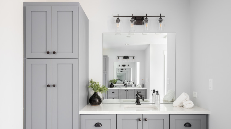 Bathroom with gray cabinets and a white vanity countertop