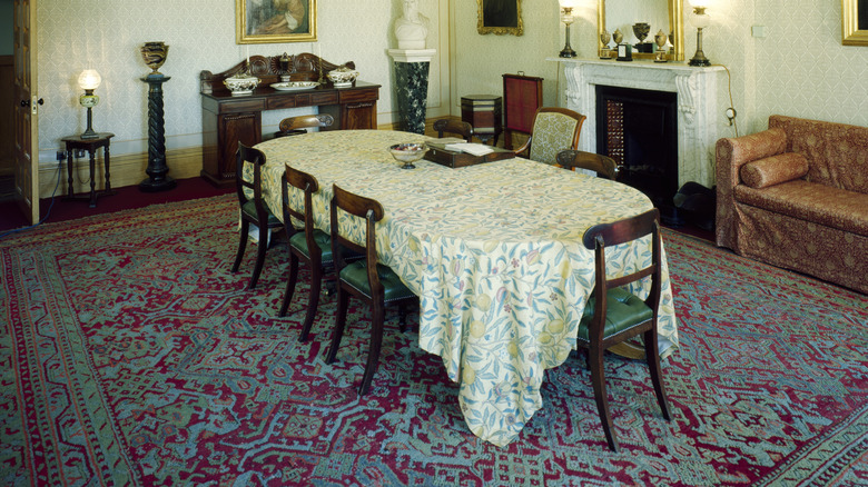 A heavy ornate rug under a dining table in an old-fashioned dining room