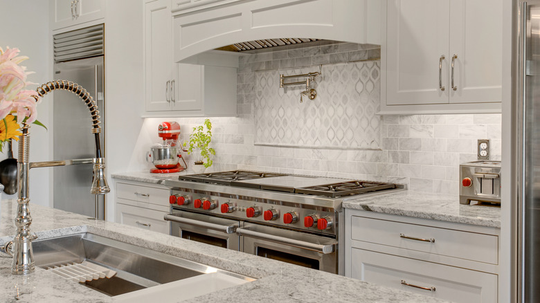 A kitchen with white cabinets and stainless steel appliances