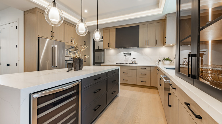 A kitchen with wooden cabinets and black pulls