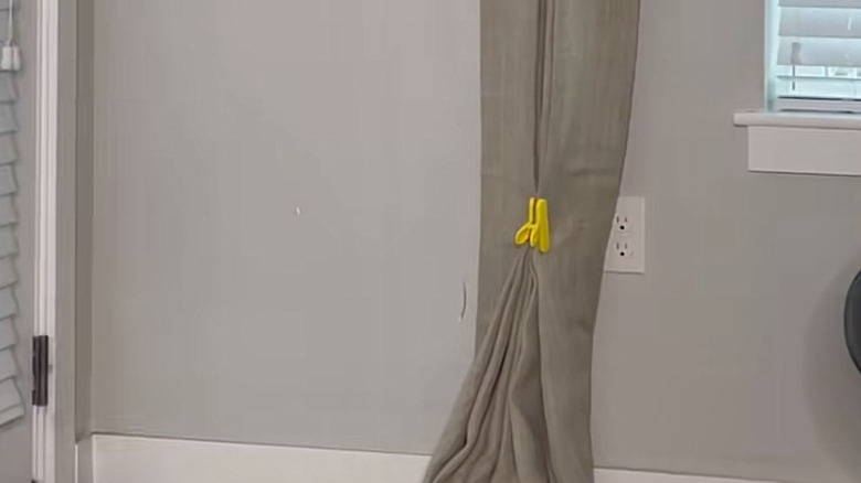 a bag clip holds fabric curtain pleats in place to train them