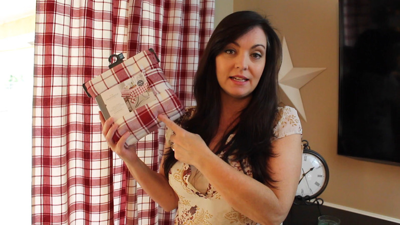 a woman shows how she made a pleated curtain out of a basic table cloth