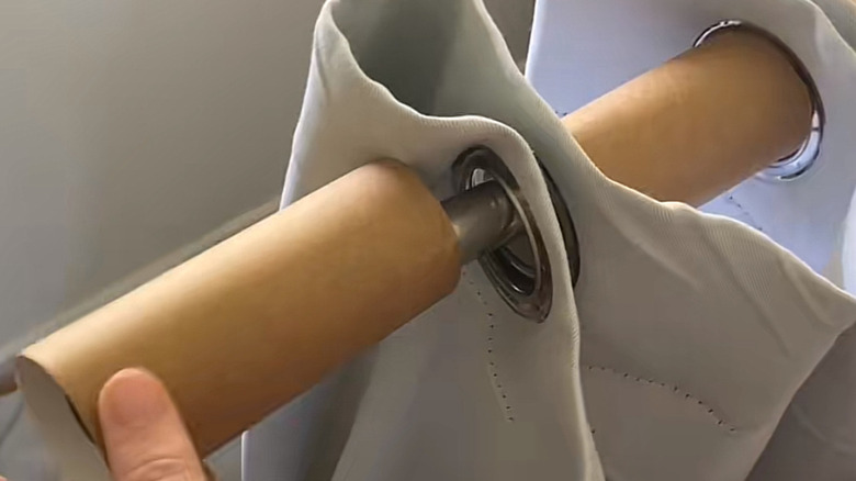 inserting toilet paper rolls between your pleats to make a grommet curtain look fuller