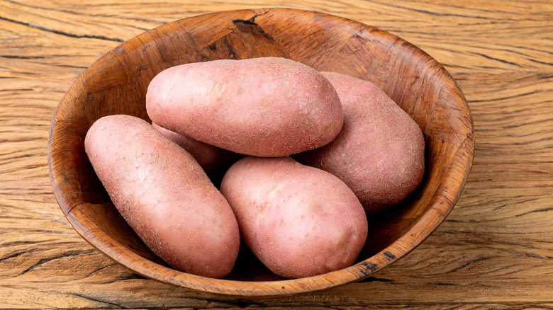 Pinkish potatoes on wooden table