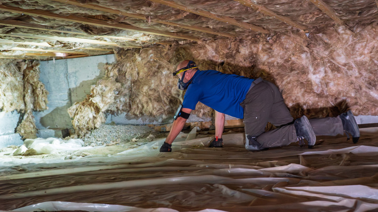 Man in crawlspace of a house.