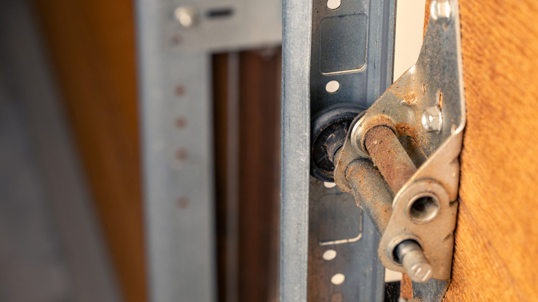 close up shot of dusty garage door hinge and roller