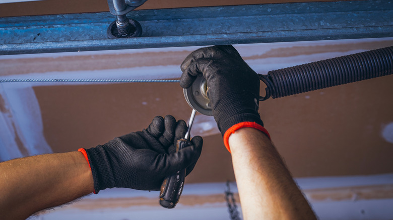 Person replacing torsion spring on garage door opener