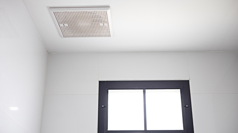 Exhaust fan on a bathroom ceiling next to a small window