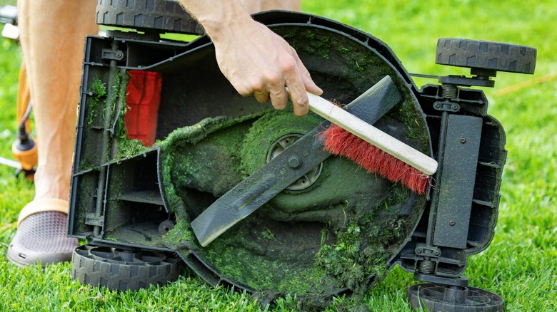 man cleaning his lawn mower