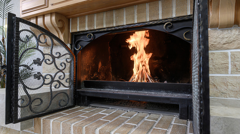 Brick fireplace with decorative doors installed