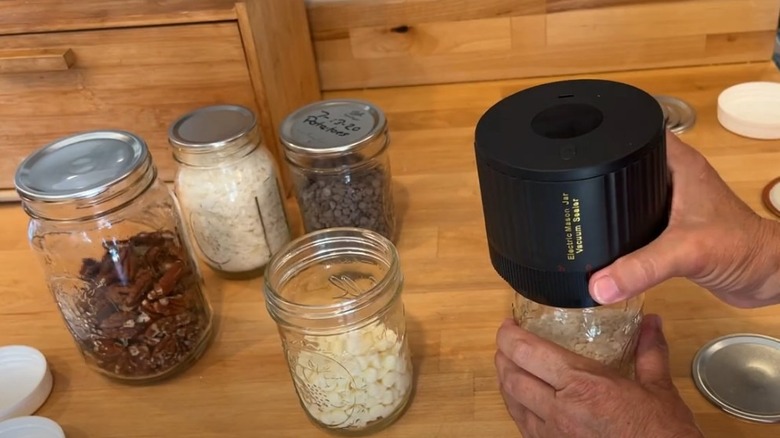 Person using an electric mason jar vacuum sealer