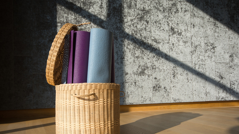 Two yoga mats in a rattan basket