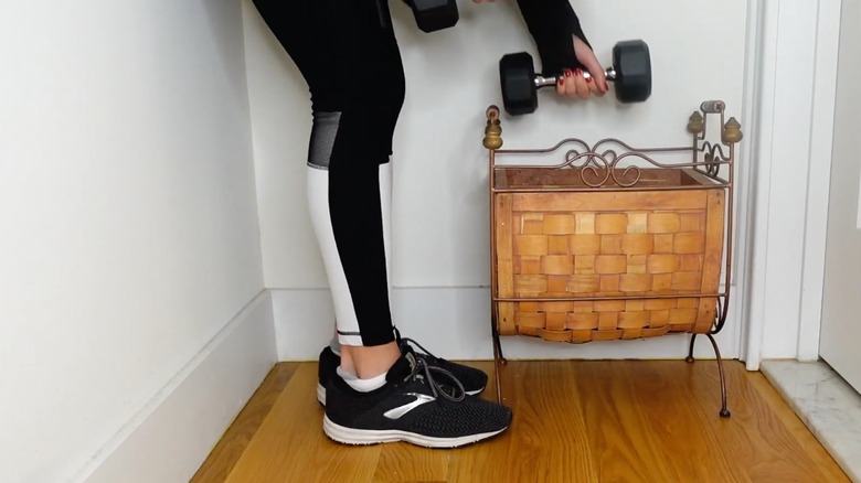 Person putting weights into a magazine rack for storage