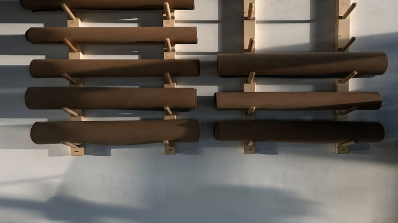 Yoga mats on wooden wall rack