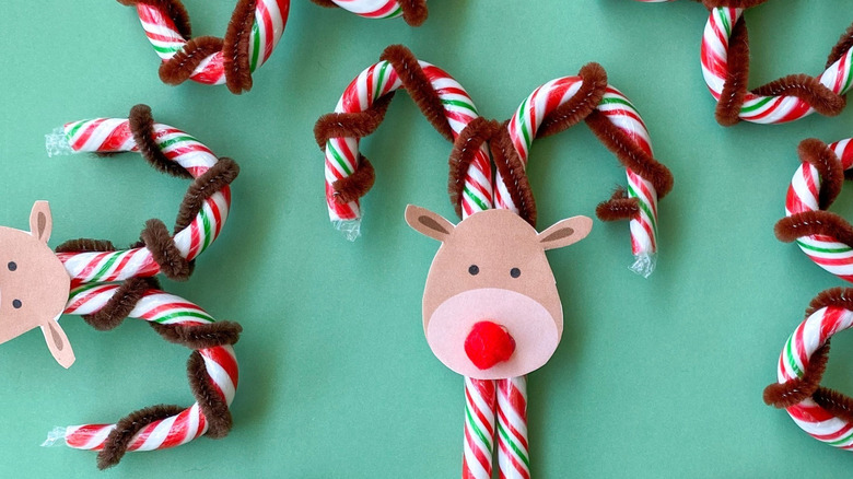 Candy canes decorated to look like reindeer on a green background