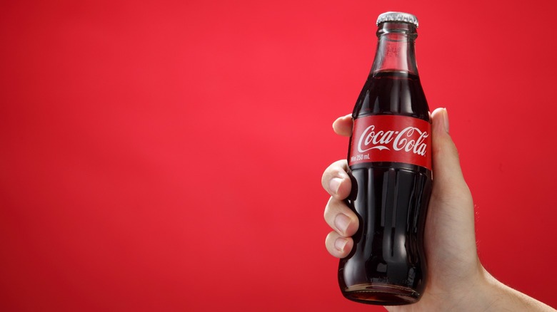 Hand holding bottle of Coke