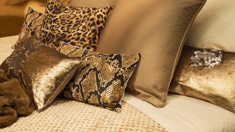 Python and cheetah throw pillows on a bed