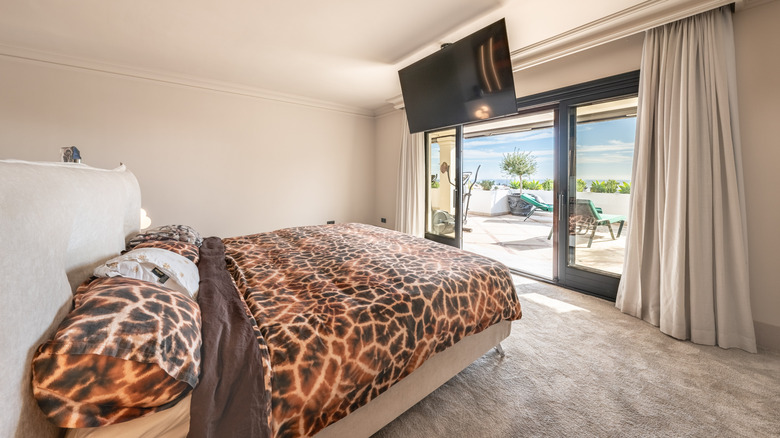 Bedroom with animal print bedding and wall-to-wall carpet