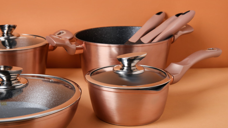 Copper cookware against a terracotta wall