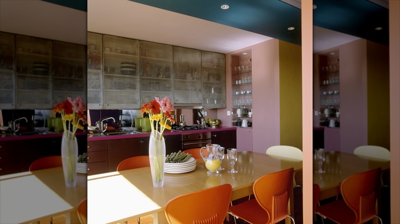 Pink kitchen cabinets paired with terracotta chairs