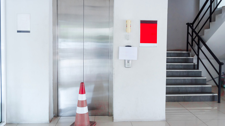 Traffic cone in front of elevator, indicating it is broken