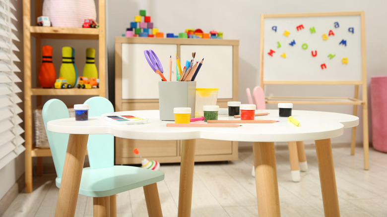 Kids' playroom with an easel and a kids' table with craft supplies on it