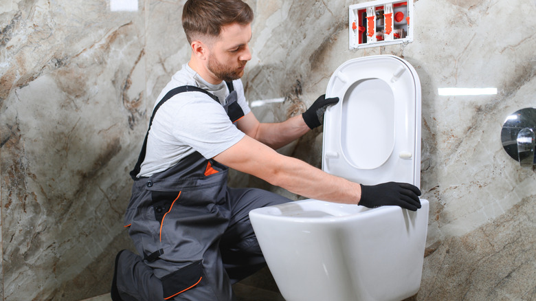 Plumber installing a toilet