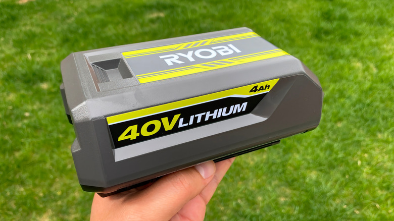 Close-up of a hand holding a 40V Ryobi battery