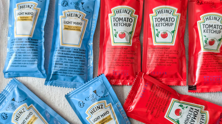 Ketchup and mayo packets sitting on a counter