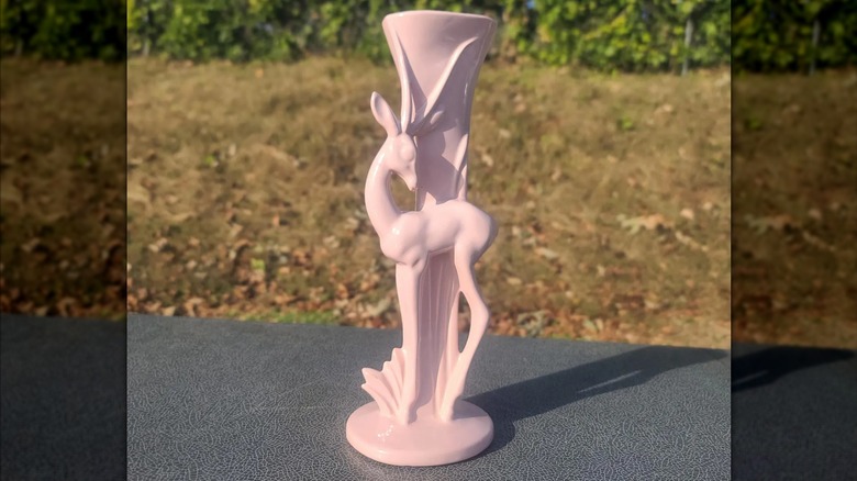 A pink vintage Haeger deer vase on a table outdoors