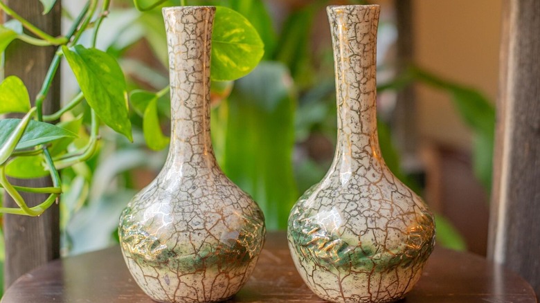 A pair of vintage McCoy flower vases in front of a plant