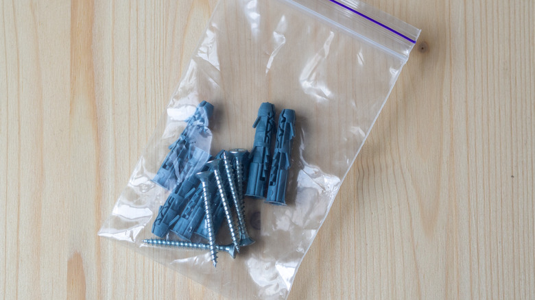 Metal screws and wall plugs inside a ziplock bag