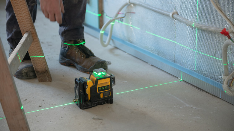 A laser level projecting green beams during a home renovation