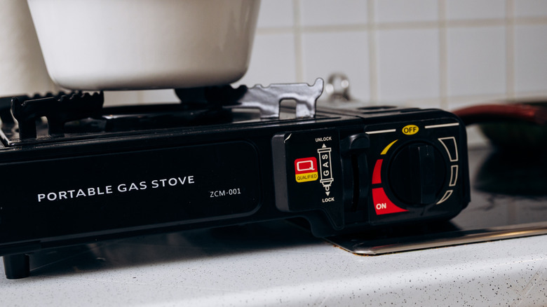 A portable camping stove on a countertop in a house