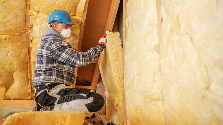 Man adding insulation to an attic