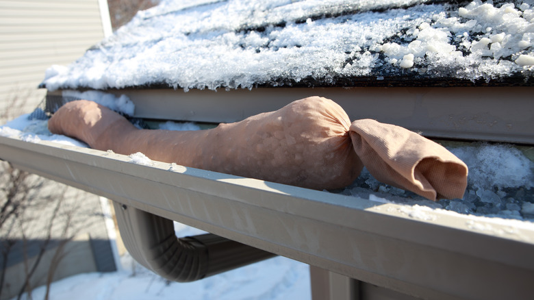 Nylon stocking filled with deicer in gutter