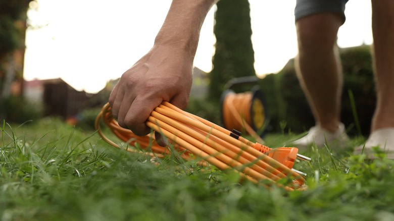 person outdoors with a coiled yellow extension cord