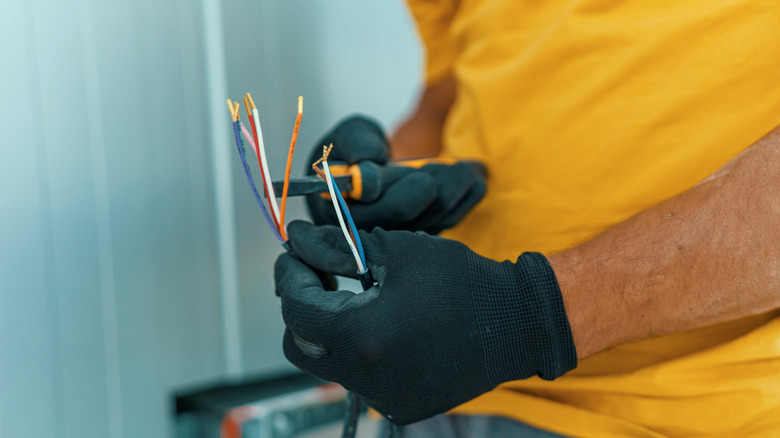 close up of a person using pliers to do electrical work