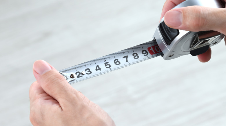 close up of person holding a tape measure