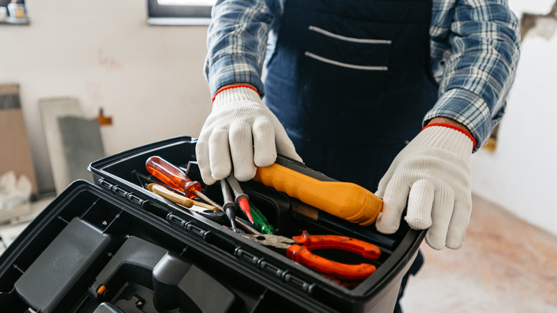 close up of person standing in front of an open toolbox