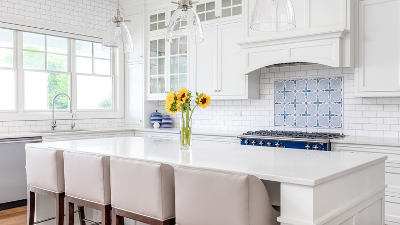 A luxury white kitchen with a patterned-tile backsplash