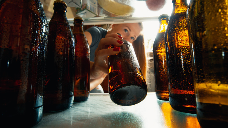 Person grabbing a beer from the fridge