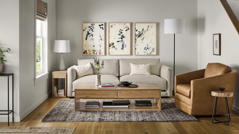 The Ford leather chair from Room & Board sits in a living room with a gray sofa and a light oak coffee table.
