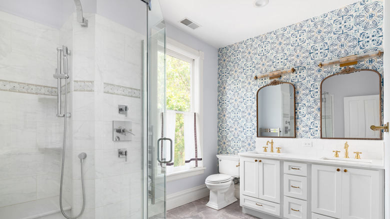 A clean and clutter-free bathroom with a tile motif wallpaper backsplash and a tiled shower