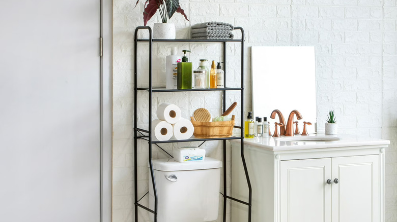Various toiletries, towels, and loo rolls organized on Mainstays' Over-the-Toilet Steel Storage Unit
