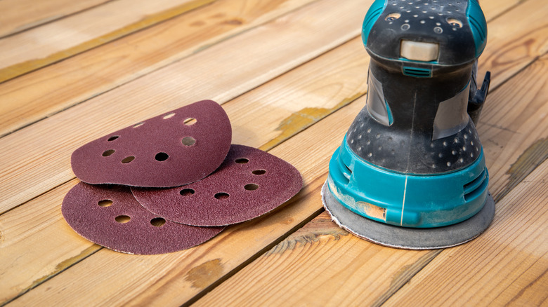 An orbital sander and sandpaper discs