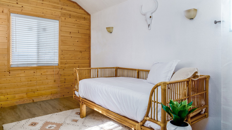 Minimalist room design with a rattan daybed and simple wall decor